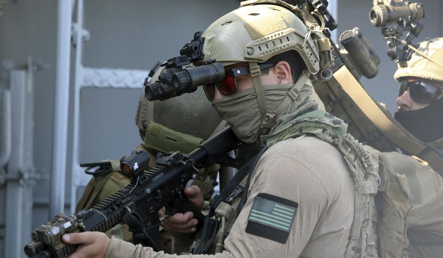In this file photo, a U.S. Navy SEAL operator, front, and colleagues during a joint U.S.-Cyprus military drill at Limassol port on Friday, Sept. 10, 2021. On Nov. 9, 26 members of the elite special forces group filed a lawsuit sued Tuesday claiming the government is arbitrarily refusing their requests for religious exemptions from the Biden administration&#x27;s COVID-19 vaccination mandate. (AP Photo/Philippos Christou) **FILE**