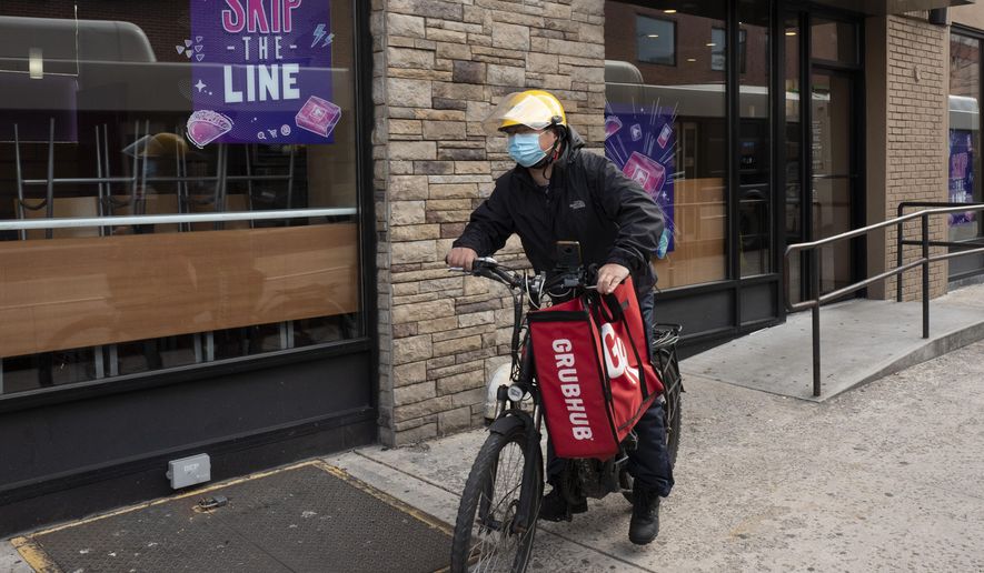 In this April 21, 2021, photo, a delivery man bikes with a food bag from Grubhub in New York. (AP Photo/Mark Lennihan) **FILE**