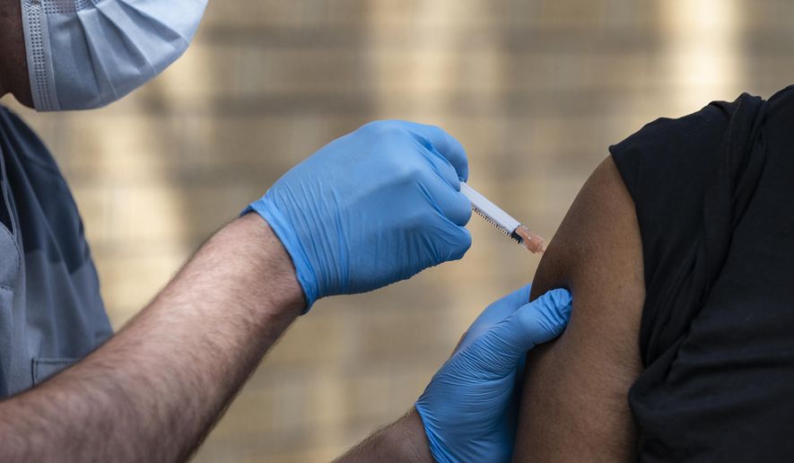 In this May 27, 2021, photo, National Guard Spc. Noah Vulpi, left, administers the Johnson &amp;amp; Johnson COVID-19 vaccine to Ira Young Jr. during a vaccination clinic held by the National Guard in Odessa, Texas. Larger U.S. businesses won&#39;t have to decide whether to require their employees to get vaccinated against COVID-19. Doing so is now federal policy, although many of the details have yet to be worked out. President Joe Biden announced sweeping new orders Thursday, Sept. 9, that will require employers with more than 100 workers to mandate immunizations or offer weekly testing. (Eli Hartman/Odessa American via AP) **FILE**