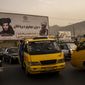 Vehicles drive past a mural paying homage to late Taliban founder Mullah Mohammad Omar, left, and the late founder of the feared Haqqani network, Jalaluddin Haqqani, in Kabul, Afghanistan, Saturday, Sept. 11, 2021. (AP Photo/Bernat Armangue)