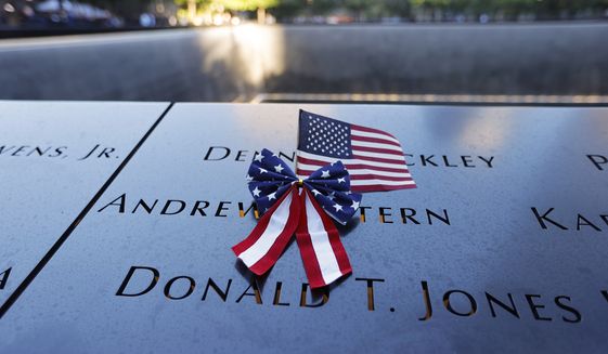 An American flag is seen on the National September 11 Memorial in New York on the 20th anniversary of the terrorist attacks, Saturday, Sept. 11, 2021. (Mike Segar/Pool Photo via AP)