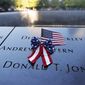 An American flag is seen on the National September 11 Memorial in New York on the 20th anniversary of the terrorist attacks, Saturday, Sept. 11, 2021. (Mike Segar/Pool Photo via AP)