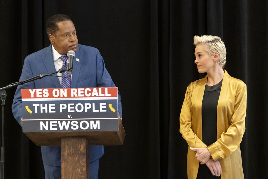 Former actor and activist Rose McGowan, right, listens to Republican conservative radio talk show host Larry Elder during a news conference at the Luxe Hotel Sunset Boulevard in Los Angeles, Sunday, Sept. 12, 2021. Elder is running to replace Democratic Gov. Gavin Newsom in the Sept. 14 recall election. McGowan was one of the earliest of dozens of women to accuse Hollywood producer Harvey Weinstein of sexual misconduct, making her a major figure in the #MeToo movement. (AP Photo/Damian Dovarganes)