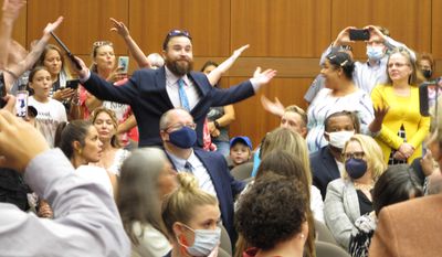 A crowd of angry, largely unmasked people objecting to Louisiana Gov. John Bel Edwards&#39; mask mandate for schools shouts in opposition to wearing a face covering at the Board of Elementary and Secondary Education meeting, Wednesday, Aug. 18, 2021, in Baton Rouge, La.. (AP Photo/Melinda Deslatte)