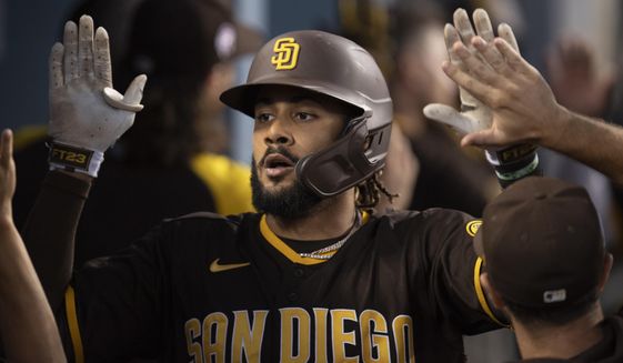San Diego Padres&#39; Fernando Tatis Jr. is greeted in the dugout after hitting a two-run home run during the fourth inning of the team&#39;s baseball game against the Los Angeles Dodgers in Los Angeles, Saturday, Sept. 11, 2021. (AP Photo/Kyusung Gong)