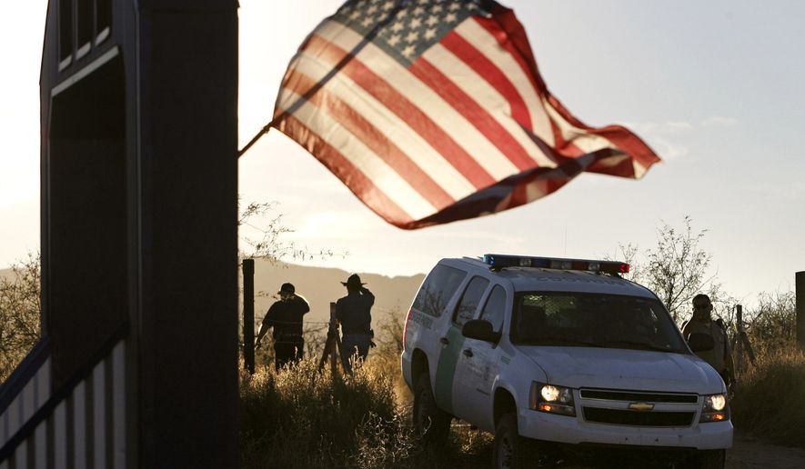 In this Dec. 15, 2010, file photo, an American flag on a nearby resident&#x27;s home waves in the breeze near a U.S. Border Patrol truck northwest of Nogales, Ariz. (Greg Bryan/Arizona Daily Star via AP, File)