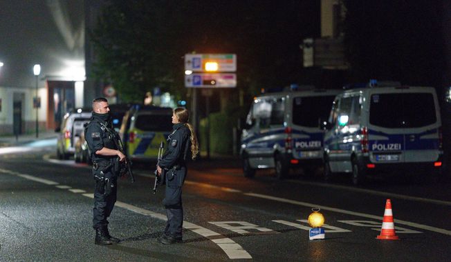 Police officers block a street in the city center during a police operation protecting the Jewish Community building in Hagen, Germany, Thursday, Sept. 16, 2021. Numerous police officers were involved in the operation, the police spoke of indications of a possible dangerous situation. (Henning Kaiser/dpa via AP)