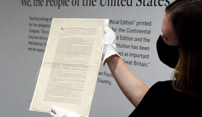 Ella Hall, a specialist in Books and Manuscripts at Sotheby&#x27;s, in New York, holds a 1787 printed copy of the U.S. Constitution, Friday, Sept. 17, 2021. Sotheby&#x27;s announced Friday 鈥� appropriately on Constitution Day 鈥� that in November it will put up for auction one of just 11 surviving copies of the Constitution from the official first printing produced for the delegates to the Constitutional Convention and for the Continental Congress. It&#x27;s the only copy that remains in private hands and has an estimate of $15 million-$20 million. (AP Photo/Richard Drew)