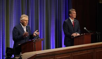 Democratic gubernatorial candidate and former governor Terry McAuliffe, left, gestures as his Republican challenger, Glenn Youngkin, looks on during a debate at the Appalachian School of Law in Grundy, Va., Thursday, Sept. 16, 2021. (AP Photo/Steve Helber)