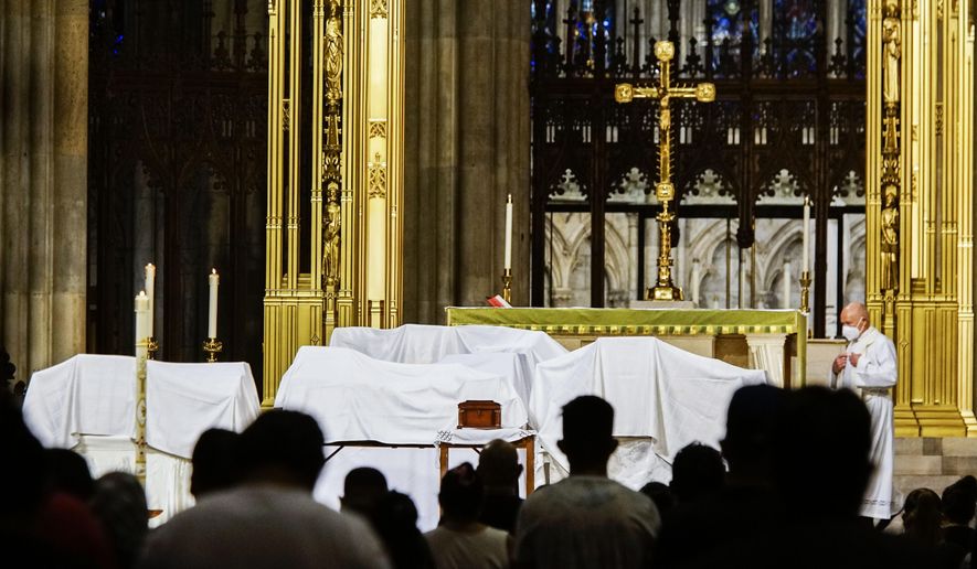 In this Saturday, July 11, 2020, file photo, mourners attend the blessing of ashes of Mexicans who died from COVID-19 during a payer a service at St. Patrick&#39;s Cathedral in New York, before they were repatriated to Mexico. The Roman Catholic Archdiocese of New York issued a statement in the summer of 2021, saying that any priest issuing an exemption letter would be “acting in contradiction” to statements from Pope Francis that receiving the vaccine is morally acceptable and responsible. (AP Photo/Eduardo Munoz Alvarez) ** FILE **