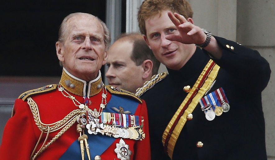 FILE - In this June 14, 2014 file photo, Britain&#39;s Prince Harry talks to Prince Philip, left, as members of the Royal family appear on the balcony of Buckingham Palace, during the Trooping The Colour parade, in central London.  In the TV program ‘Prince Philip: The Royal Family Remembers’ released late Saturday Sept. 18, 2021, members of the royal family spoke admiringly of the late Duke of Edinburgh’s barbecuing skills and Prince Harry described how his grandfather would “never probe” but listen intently about his two tour of duties to Helmand province during the war in Afghanistan. (AP Photo/Lefteris Pitarakis, File)
