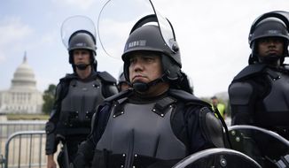 Police in riot gear patrol as people attend a rally near the U.S. Capitol in Washington, Saturday, Sept. 18, 2021. The rally was planned by allies of former President Donald Trump and aimed at supporting the so-called &quot;political prisoners&quot; of the Jan. 6 insurrection at the U.S. Capitol. (AP Photo/Brynn Anderson)