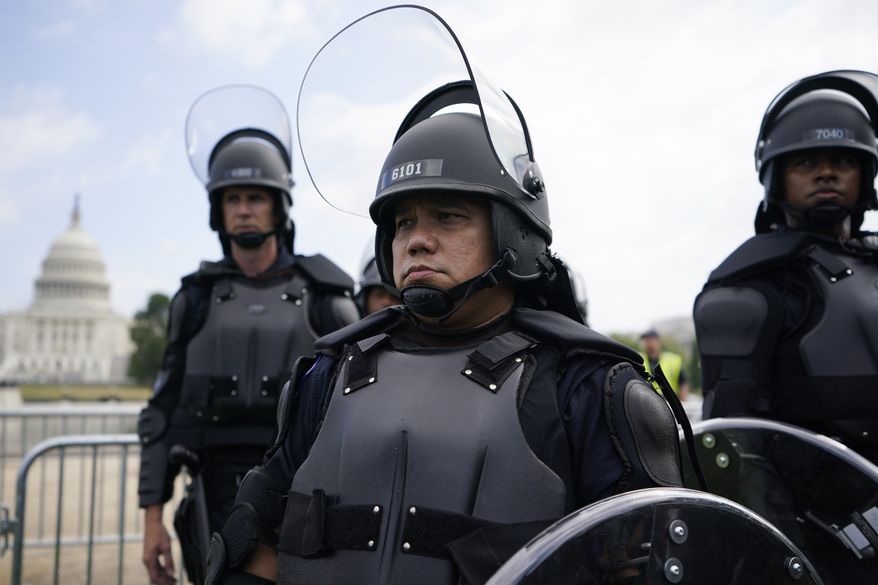 Police in riot gear patrol as people attend a rally near the U.S. Capitol in Washington, Saturday, Sept. 18, 2021. The rally was planned by allies of former President Donald Trump and aimed at supporting the so-called &quot;political prisoners&quot; of the Jan. 6 insurrection at the U.S. Capitol. (AP Photo/Brynn Anderson)