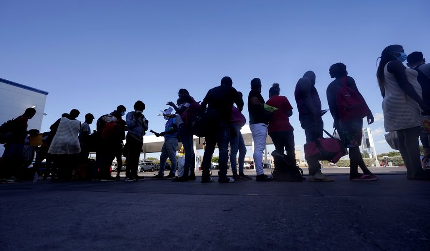 Migrants, mostly from Haiti, wait for a bus after they were processed and released after spending time at a makeshift camp near the International Bridge, Sunday, Sept. 19, 2021, in Del Rio, Texas. President Joe Biden&#x27;s administration is nearing a final plan to expel many of the thousands of Haitian migrants who have suddenly crossed into a Texas border city from Mexico and to fly them back to their Caribbean homeland. (AP Photo/Eric Gay)