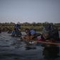 Migrants, many from Haiti, wade across the Rio Grande from Del Rio, Texas, to return to Ciudad Acuña, Mexico, late Sunday, Sept. 19, 2021, to avoid deportation to Haiti from the U.S.  The U.S. is flying Haitians camped in a Texas border town back to their homeland and blocking others from crossing the border from Mexico in a massive show of force that signals the beginning of what could be one of America&#39;s swiftest, large-scale expulsions of migrants or refugees in decades. (AP Photo/Felix Marquez)