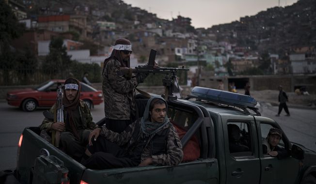 Taliban fighters sit on the back of a pickup truck as they stop on a hillside in Kabul, Afghanistan, Sunday, Sept. 19, 2021. (AP Photo/Felipe Dana)