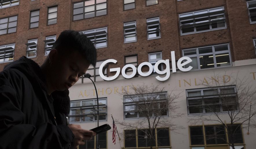 In this photo dated Monday, Dec. 17, 2018, a man using a mobile phone walks past Google offices in New York. (AP Photo/Mark Lennihan) **FILE**