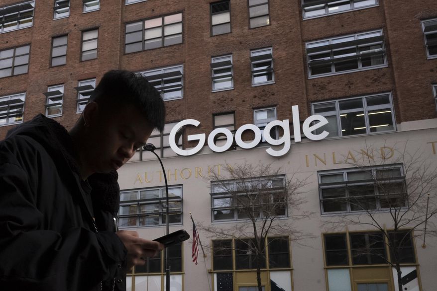 In this file photo dated Monday, Dec. 17, 2018, a man using a mobile phone walks past Google offices in New York. Google is planning to buy New York&#39;s St.  John’s Terminal for $2.1 billion, making it the anchor of its Hudson Square campus. Alphabet and Google Chief Financial Officer Ruth Porat said Tuesday, Sept. 21, 2021,  that the company is looking to invest more than $250 million in its New York campus this year. (AP Photo/Mark Lennihan)  **FILE**