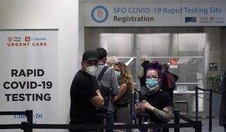 In this Oct. 15, 2020, file photo, United Airlines passengers wait in line to register at the SFO COVID-19 rapid testing site at San Francisco International Airport in San Francisco. San Francisco is requiring all workers at San Francisco International Airport to get vaccinated against COVID-19. Employees who are exempt must undergo weekly testing. The mandate announced Tuesday, Sept. 21, 2021, applies to roughly 46,000 on-site personnel, including employees of contractors and retail tenants. (AP Photo/Jeff Chiu, File)