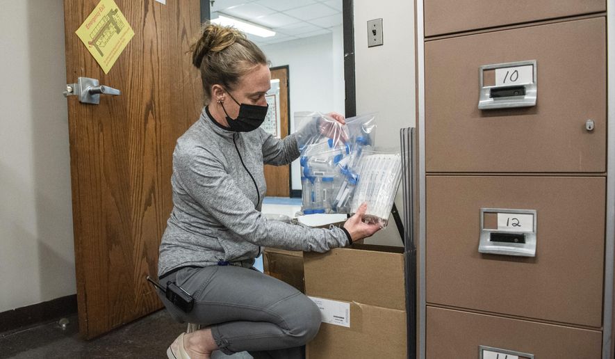 Missy Gendron RN, LHS school nurse, unpacks pooled COVID-19 testing materials on Tuesday, Sept. 21, 2021, at Lewiston High School in Lewiston, Maine. Gendron is going to be doing a walk through with staff next week. Classroom pooled testing is planned for the week following. Consent for COVID-19 pooled testing is being collected from parents now. (Andree Kehn/Sun Journal via AP)