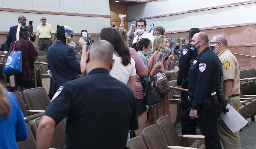 People confront police and security officers over an indoor face mask mandate during a commission meeting at the Clark County Government Center Tuesday, Sept. 21, 2021. (Ricardo Torres-Cortez/Las Vegas Sun via AP) **FILE**