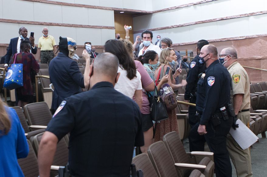 People confront police and security officers over an indoor face mask mandate during a commission meeting at the Clark County Government Center Tuesday, Sept. 21, 2021. (Ricardo Torres-Cortez/Las Vegas Sun via AP) **FILE**