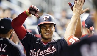 Washington Nationals&#39; Juan Soto is cheered by the team after hitting a two-run home run in the third inning of a baseball game against the Miami Marlins, Wednesday, Sept. 22, 2021, in Miami. (AP Photo/Marta Lavandier)
