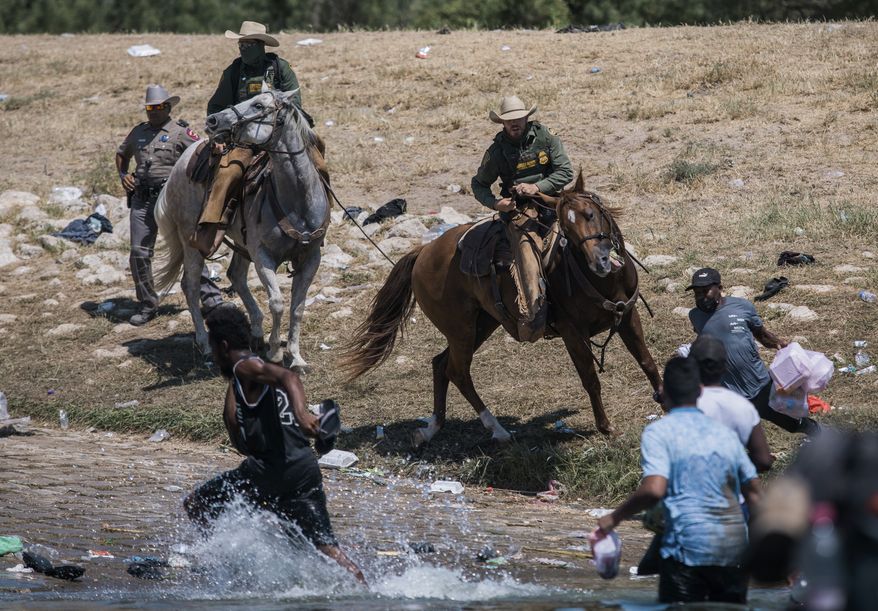U.S. Customs and Border Protection mounted officers attempt to contain migrants as they cross the Rio Grande from Ciudad Acuna, Mexico, into Del Rio, Texas, Sunday, Sept. 19, 2021. The White House is facing sharp condemnation from Democrats for its handling of the influx of Haitian migrants at the U.S. southern border, after images of U.S. Border Patrol agents on horseback using aggressive tactics went viral. (AP Photo/Felix Marquez) **FILE**