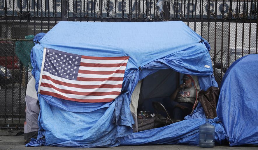 In this March 20, 2020, file photos, a man smokes inside a tent on skid row in Los Angeles. The 9th U.S. Court of Appeals on Thursday, Sept. 23, 2021, overturned a federal judge’s sweeping order that required the city and county of Los Angeles to quickly find shelter for all homeless people living on downtown’s Skid Row.  (AP Photo/Marcio Jose Sanchez, File) **FILE**