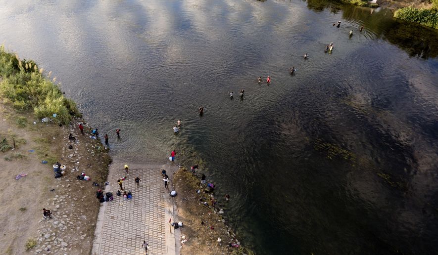 Migrants, many from Haiti, wade back and forth between Texas and Mexico across the Rio Grande, Wednesday, Sept. 22, 2021, in Del Rio, Texas. (AP Photo/Julio Cortez)