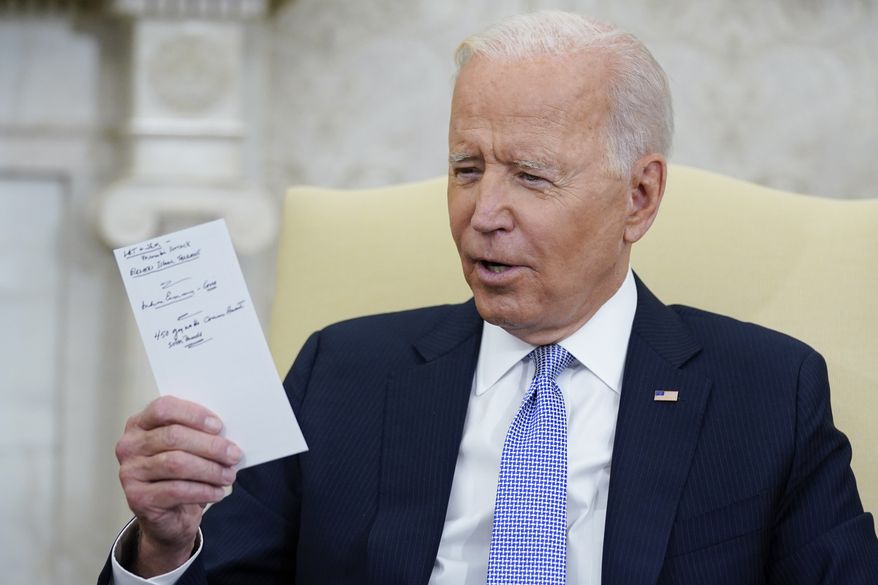 President Joe Biden holds notes as he meets with Indian Prime Minister Narendra Modi in the Oval Office of the White House, Friday, Sept. 24, 2021, in Washington. (AP Photo/Evan Vucci)