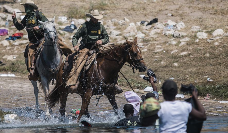 In this Sept. 19, 2021, photo, U.S. Customs and Border Protection mounted officers attempt to contain migrants as they cross the Rio Grande from Ciudad Acuña, Mexico, into Del Rio, Texas. The Border Patrol&#39;s treatment of Haitian migrants, they say, is just the latest in a long history of discriminatory U.S. policies and of indignities faced by Black people, sparking new anger among Haitian Americans, Black immigrant advocates and civil rights leaders.( AP Photo/Felix Marquez) **FILE**
