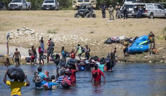 Migrants, most from Haiti, cross the Rio Grande towards Del Rio, Texas, from Ciudad Acuña, Mexico, Thursday, Sept. 23, 2021. (AP Photo/Felix Marquez)