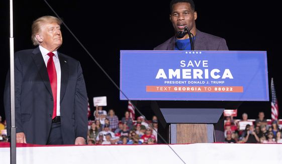 Former President Donald Trump listens as Georgia Senate candidate Herschel Walker speaks during his Save America rally in Perry, Ga., on Saturday, Sept. 25, 2021. (AP Photo/Ben Gray)