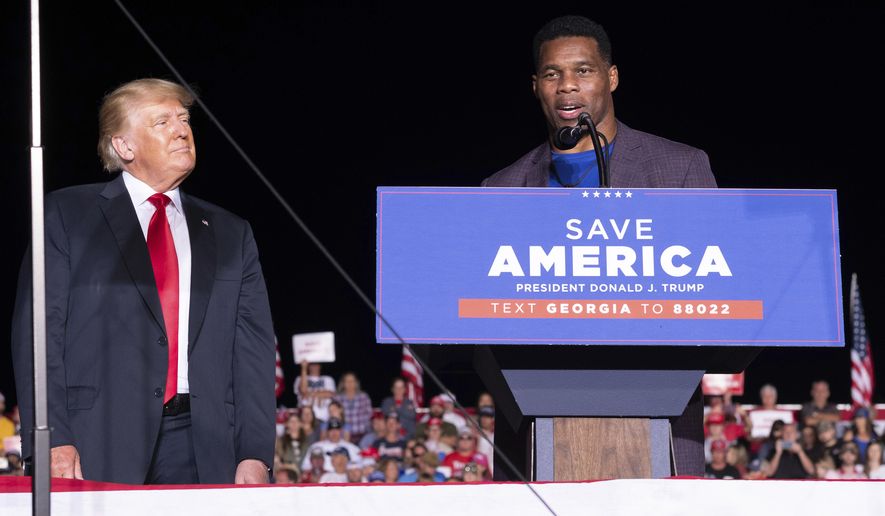 Former President Donald Trump listens as Georgia Senate candidate Herschel Walker speaks during his Save America rally in Perry, Ga., on Saturday, Sept. 25, 2021. (AP Photo/Ben Gray) **FILE**