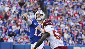 Buffalo Bills quarterback Josh Allen (17) throws a pass over Washington Football Team&#39;s Jamin Davis (52) to Dawson Knox for a touchdown during the first half of an NFL football game Sunday, Sept. 26, 2021, in Orchard Park, N.Y. (AP Photo/Jeffrey T. Barnes)