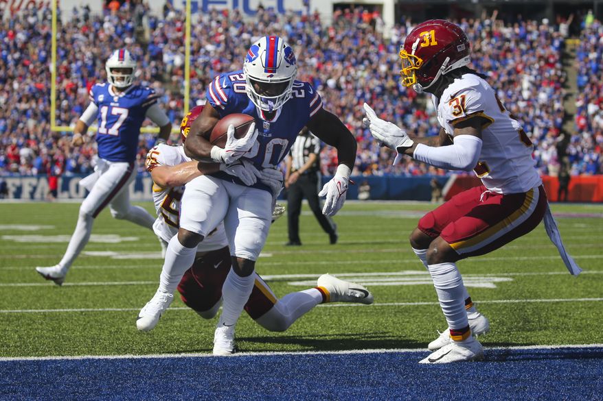 Buffalo Bills running back Zack Moss (20) runs past Washington Football Team's Cole Holcomb (55) for a touchdown as quarterback Josh Allen (17) watches during the first half of an NFL football game Sunday, Sept. 26, 2021, in Orchard Park, N.Y. (AP Photo/Jeffrey T. Barnes)