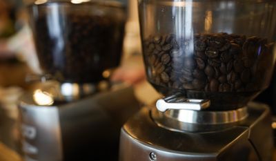 Coffee beans are seen in grinders at Vigilante Coffee, Wednesday, Sept. 1, 2021, in College Park, Md. (AP Photo/Julio Cortez)