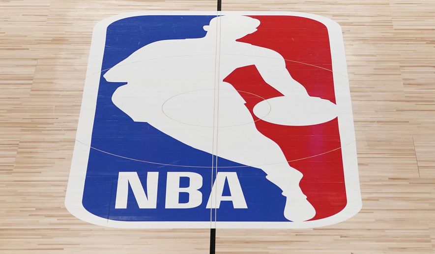 The NBA logo in shown on a basketball court in Lake Buena Vista, Fla., in this Friday, Aug. 28, 2020, file photo. Pacers coach Rick Carlisle says his new team has a “very high” vaccination rate but declined to give a specific number because of privacy concerns. He did say Monday during NBA media day that all members of the Indiana coaching staff are fully vaccinated. Carlisle is back in Indiana, where he coached from 2003 through 2007. Training camps open Tuesday and the pandemic will affect a third NBA season and already means some players will be missing on media day.(AP Photo/Ashley Landis, Pool, File)