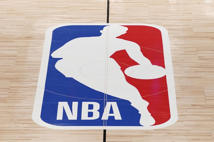 The NBA logo in shown on a basketball court in Lake Buena Vista, Fla., in this Friday, Aug. 28, 2020, file photo. Pacers coach Rick Carlisle says his new team has a “very high” vaccination rate but declined to give a specific number because of privacy concerns. He did say Monday during NBA media day that all members of the Indiana coaching staff are fully vaccinated. Carlisle is back in Indiana, where he coached from 2003 through 2007. Training camps open Tuesday and the pandemic will affect a third NBA season and already means some players will be missing on media day.(AP Photo/Ashley Landis, Pool, File)