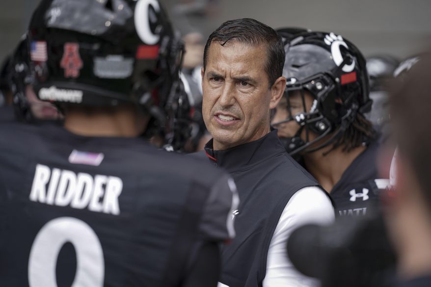 Cincinnati head coach Luke Fickell speaks with quarterback Desmond Ridder (9) prior to an NCAA college football game against Miami (Ohio) in Cincinnati, in this Saturday, Sept. 4, 2021, file photo. Cincinnati coach Luke Fickell talks about the opportunity the No. 7 Bearcats have to impress the nation when they travel to South Bend, Indiana, to face No. 9 Notre Dame. (AP Photo/Jeff Dean, File) **FILE**