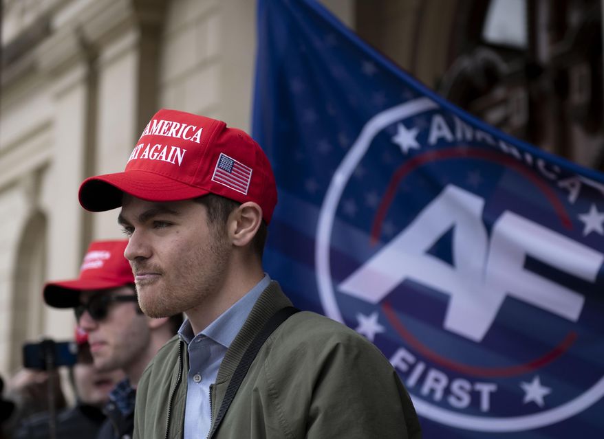 In this Nov. 11, 2020, photo, far-right activist Nick Fuentes holds a rally at the Michigan State Capitol in Lansing, Mich. Fuentes received a donation of about $250,000 from a French computer programmer in late 2020 and spent the coming weeks encouraging his tens of thousands of followers to lay siege to the U.S. Capitol. The money slipped quietly into the U.S., not triggering alerts it might have had it landed via traditional banking channels. (Nicole Hester/Ann Arbor News via AP) **FILE**