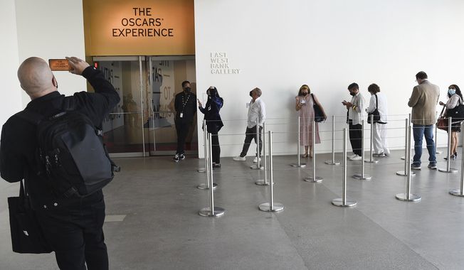FILE - People wait up for The Oscars Experience exhibit at the Academy Museum on Tuesday, Sept. 21, 2021, in Los Angeles. The Academy Museum of Motion Pictures opens in Los Angeles Thursday. (Photo by Richard Shotwell/Invision/AP, File)