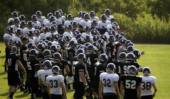 Northwestern football players gather during practice at the University of Wisconsin-Parkside campus in Kenosha, Wisc., in this Monday, Aug. 17, 2015, file photo. College football players and some other athletes in revenue-generating sports are employees of their schools, the National Labor Relations Board’s top lawyer said in a memo Wednesday, Sept. 29, 2021, that would allow the players to unionize and otherwise negotiate over their working conditions. The nine-page NLRB memo revisited a case involving Northwestern University football players who were thwarted from forming a union when the board said that taking their side “would not promote stability in labor relations.”(AP Photo/Jeffrey Phelps, File) **FILE**