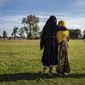 Afghan refugee girls watch a soccer game from a distance near the Village at the Fort McCoy U.S. Army base on Thursday, Sept. 30, 2021 in Fort McCoy, Wis.   The fort is one of eight military installations across the country that are temporarily housing the tens of thousands of Afghans who were forced to flee their homeland in August after the U.S. withdrew its forces from Afghanistan and the Taliban took control. (Barbara Davidson/Pool Photo via AP)