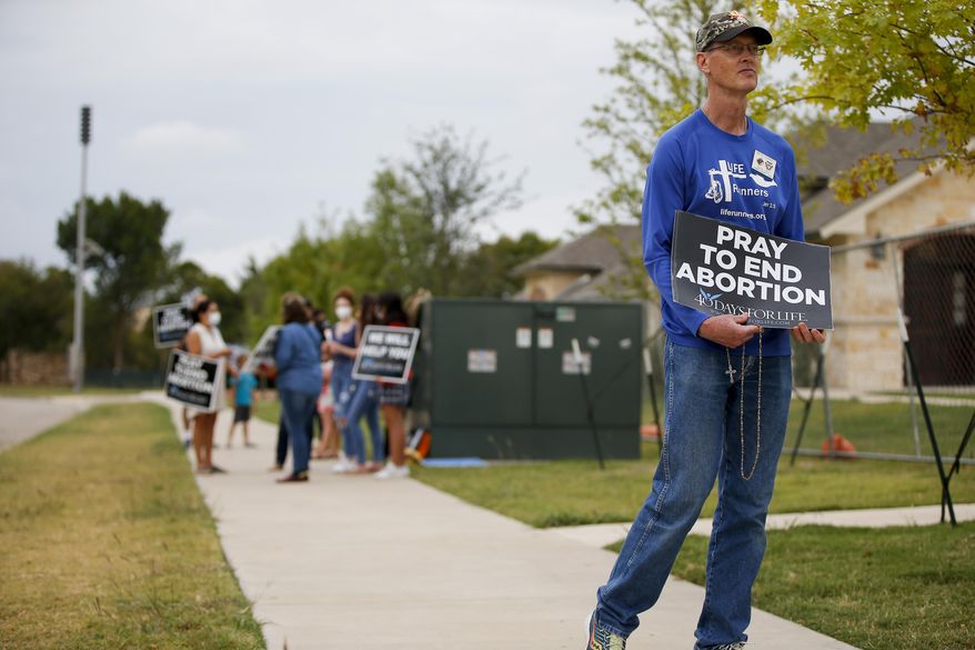 Timothy Dougherty and about a dozen other anti-abortion demonstrators protest outside of a Whole Women's Health of North Texas, Friday, Oct. 1, 2021, in McKinney, Texas. A federal judge did not say when he would rule following a nearly three-hour hearing in Austin during which abortion providers sought to block the nation's most restrictive abortion law, which has banned most abortions in Texas since early September. (AP Photo/Brandon Wade)