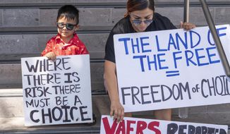 In this Thursday, Sept. 9, 2021, file photo, Evelyn Guillen with her 3-year-old son, joins anti-vaccine protesters outside the Los Angeles Unified School District administrative offices in Los Angeles. (AP Photo/Damian Dovarganes, File)