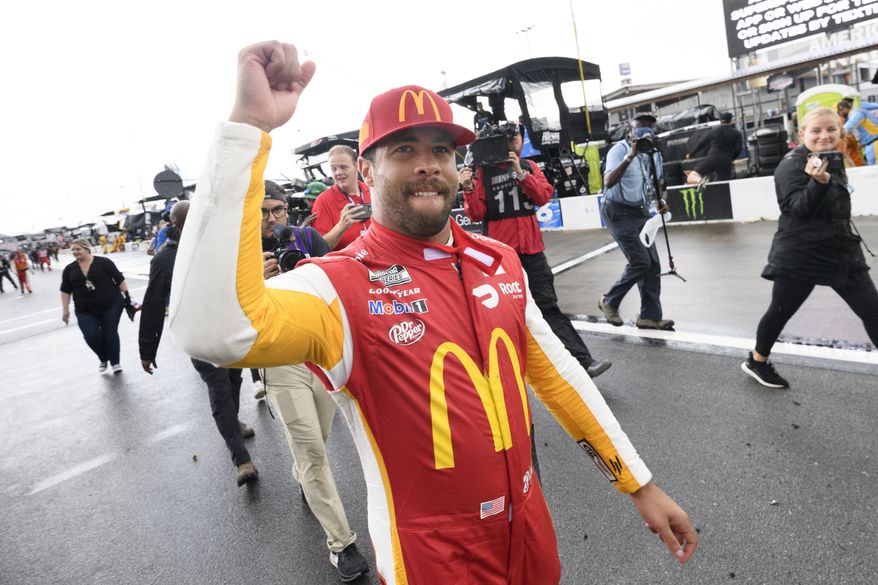 Bubba Wallace celebrates after being pronounced the winner while waiting out a rain delay before which he was the leader in a NASCAR Cup series auto race Monday, Oct. 4, 2021, in Talladega, Ala. (AP Photo/John Amis)