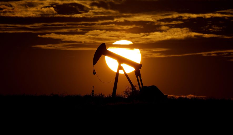 In this Wednesday, April 8, 2020, file photo, the sun sets behind an idle pump jack near Karnes City, USA. (AP Photo/Eric Gay, File)