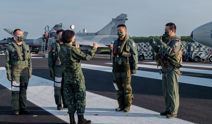 In this photo released by the Taiwan Presidential Office, Taiwanese President Tsai Ing-wen, center, speaks with military personnel near aircraft parked on a highway in Jiadong, Taiwan, Wednesday, Sept. 15, 2021. Four military aircraft landed on the highway and took off again on Wednesday as part of Taiwan's five-day Han Guang military exercise designed to prepare the island's forces for an attack by China, which claims Taiwan as part of its own territory. (Taiwan Presidential Office via AP) ** FILE **